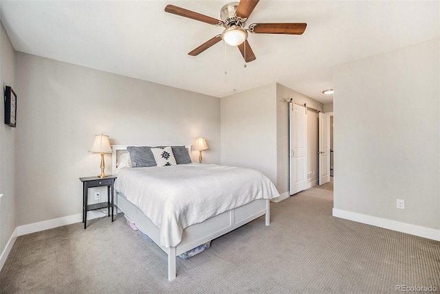 carpeted bedroom featuring a barn door and ceiling fan