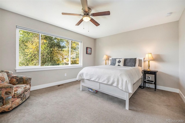 carpeted bedroom with multiple windows and ceiling fan