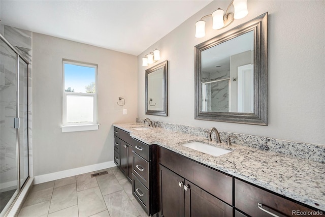 bathroom featuring a shower with door, vanity, and tile patterned flooring