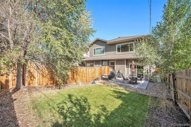 rear view of house featuring a patio area and a lawn