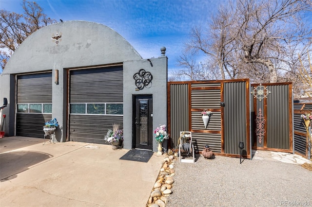 view of outbuilding featuring a garage and a gate