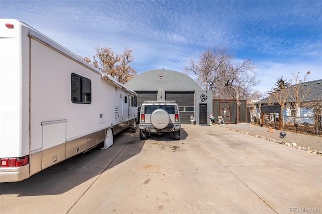 view of front of property with a garage, fence, an outdoor structure, and stucco siding