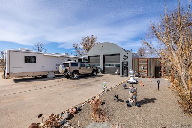 view of front of home with a garage, an outdoor structure, driveway, and stucco siding