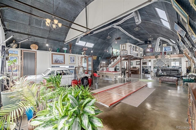 interior space featuring a notable chandelier, high vaulted ceiling, concrete flooring, and stairs