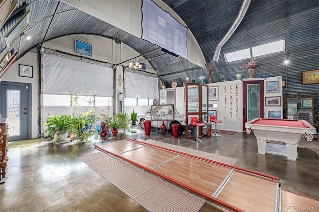 interior space featuring high vaulted ceiling, concrete flooring, and billiards