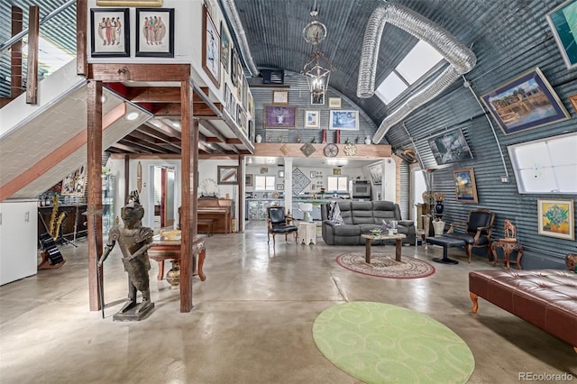 living room with a skylight, a healthy amount of sunlight, high vaulted ceiling, and finished concrete floors