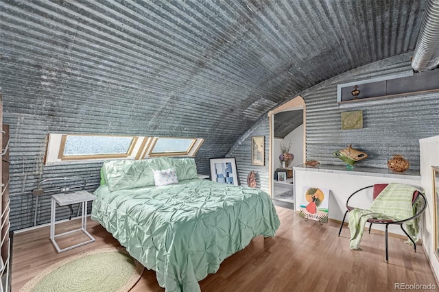 bedroom featuring lofted ceiling and wood finished floors