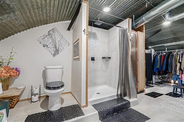 bathroom with tile patterned flooring, toilet, baseboards, and a stall shower