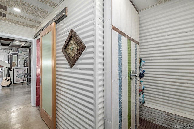 corridor featuring a barn door and finished concrete flooring