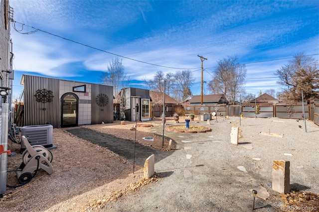 view of yard with cooling unit, an outbuilding, and fence