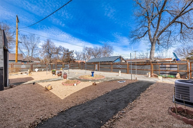 view of yard with central AC and fence