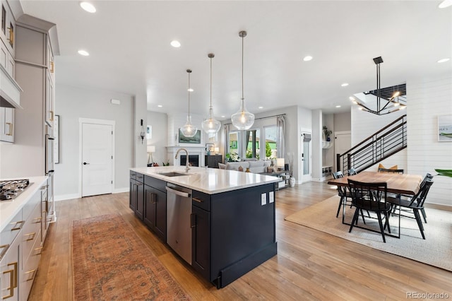 20998 E 60th Pl, Aurora, CO 80019 - kitchen with stainless steel dishwasher, open floor plan, light countertops, light wood-style flooring, and recessed lighting