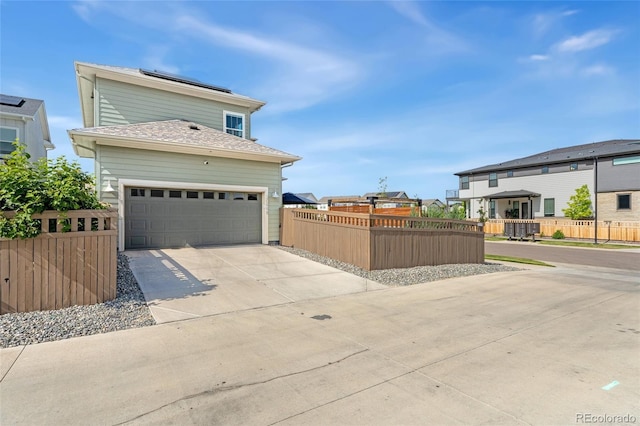20998 E 60th Pl, Aurora, CO 80019 - view of front of house featuring concrete driveway, solar panels, a shingled roof, and a residential view