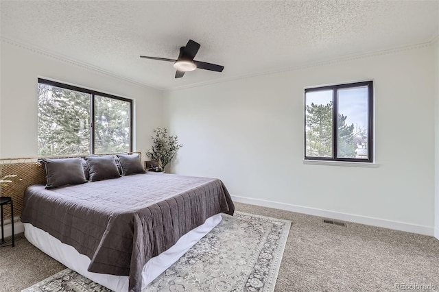 bedroom with baseboards, ceiling fan, a textured ceiling, and carpet