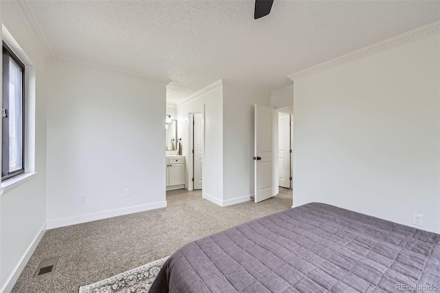 unfurnished bedroom with visible vents, baseboards, light colored carpet, ornamental molding, and a textured ceiling