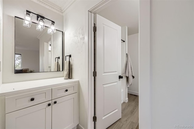 bathroom with vanity, wood finished floors, and ornamental molding