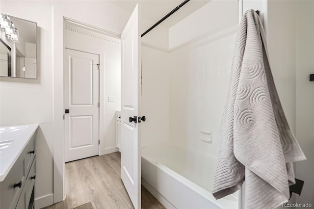 bathroom featuring vanity, bathing tub / shower combination, and wood finished floors