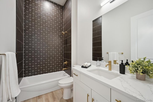 full bathroom featuring toilet, tiled shower / bath combo, vanity, and wood-type flooring