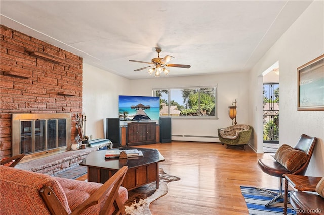6920 W 47th Pl, Wheat Ridge, CO 80033 - living room with wood finished floors, ceiling fan, a baseboard heating unit, and a large fireplace