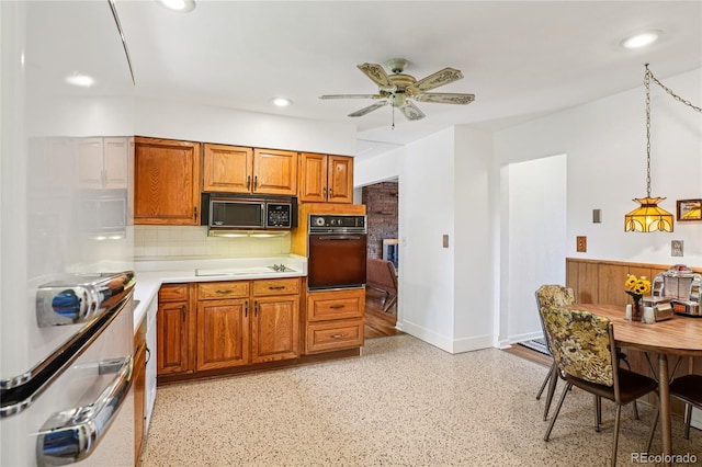 6920 W 47th Pl, Wheat Ridge, CO 80033 - kitchen featuring black appliances, decorative backsplash, light countertops, brown cabinets, and a ceiling fan