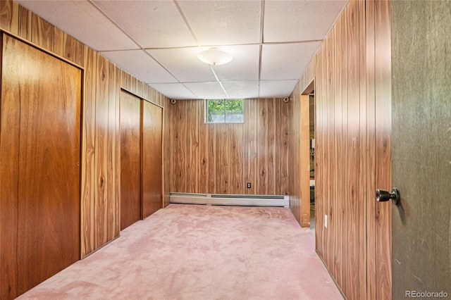 6920 W 47th Pl, Wheat Ridge, CO 80033 - carpeted empty room featuring wood walls, a baseboard radiator, and a paneled ceiling