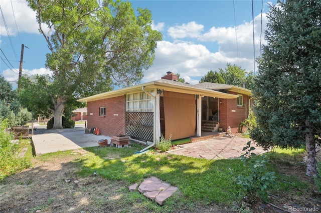 6920 W 47th Pl, Wheat Ridge, CO 80033 - rear view of house featuring brick siding, a patio area, and a chimney