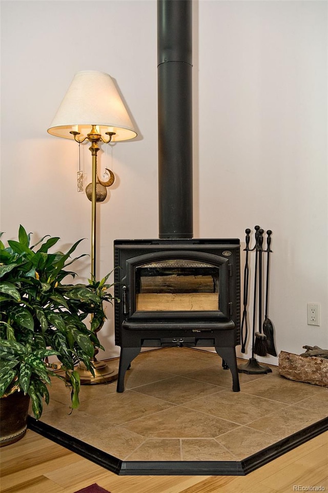 details with a wood stove and hardwood / wood-style floors