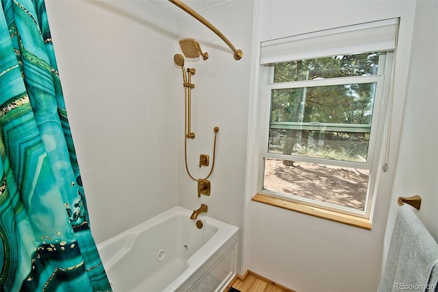 bathroom featuring a wealth of natural light, wood-type flooring, and shower / tub combo