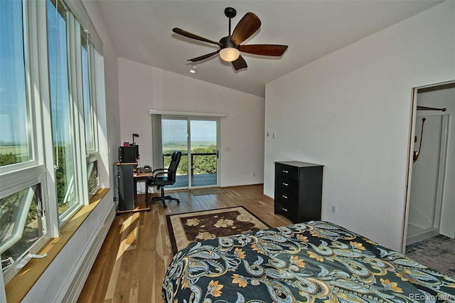 bedroom featuring access to outside, ceiling fan, dark hardwood / wood-style floors, and vaulted ceiling