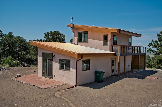 rear view of house with a balcony and a patio area