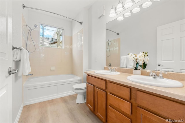 3329 Molly Ln, Broomfield, CO 80023 - bathroom featuring wood finished floors, bathing tub / shower combination, toilet, and double vanity