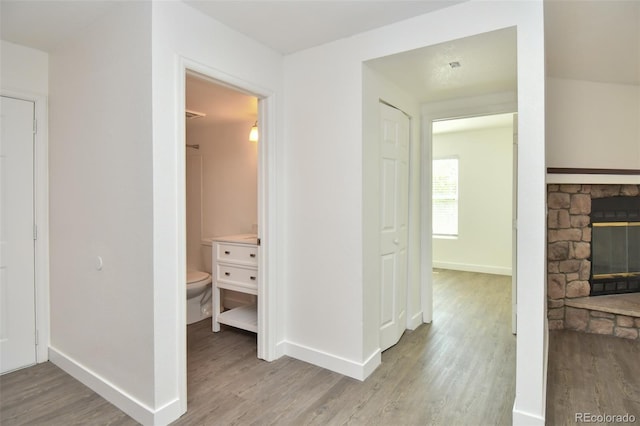 corridor featuring baseboards and wood finished floors