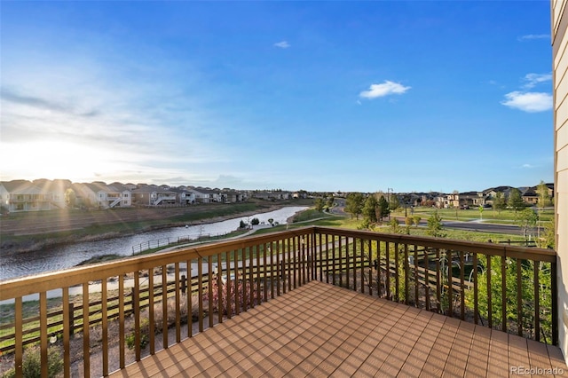 wooden terrace with a water view and a residential view