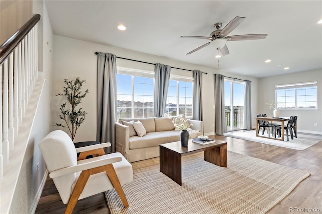 living area with wood finished floors, baseboards, stairway, recessed lighting, and a ceiling fan