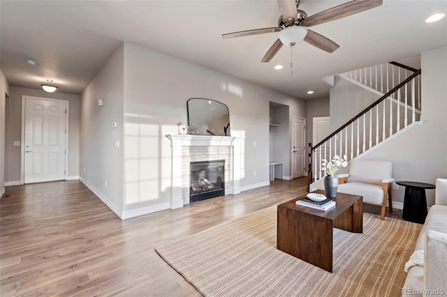 living room featuring baseboards, wood finished floors, and stairway
