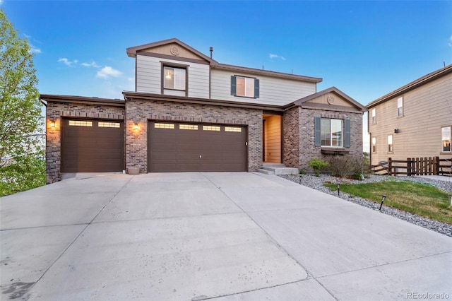 traditional home with brick siding, a garage, fence, and concrete driveway
