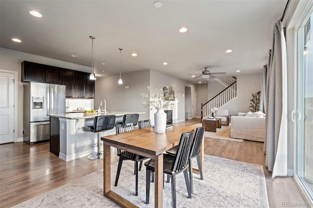 dining room featuring stairs, recessed lighting, a ceiling fan, baseboards, and wood finished floors