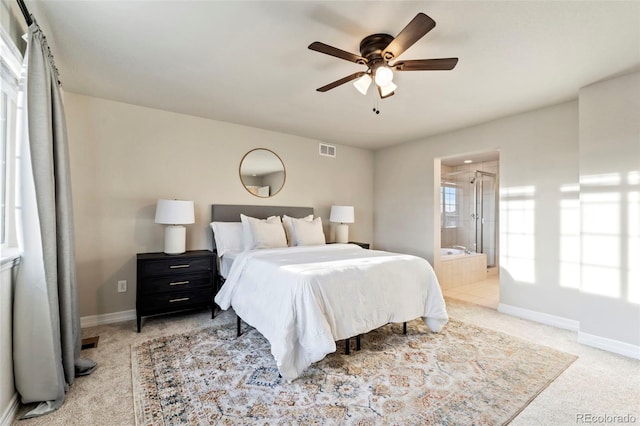 bedroom featuring baseboards, ensuite bathroom, light colored carpet, and visible vents