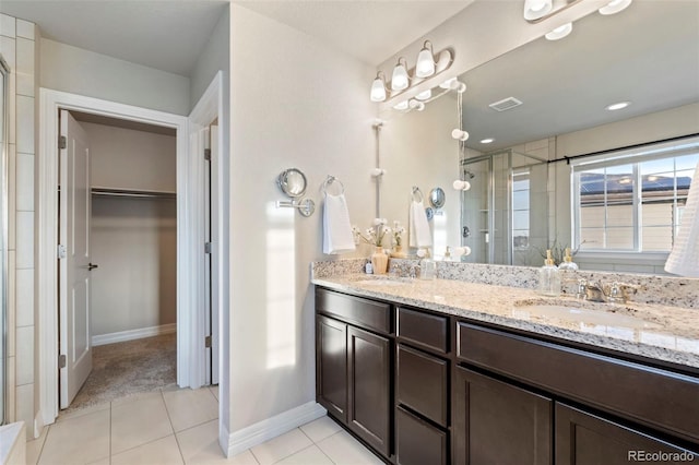 bathroom featuring a sink, tile patterned floors, a shower stall, a spacious closet, and visible vents