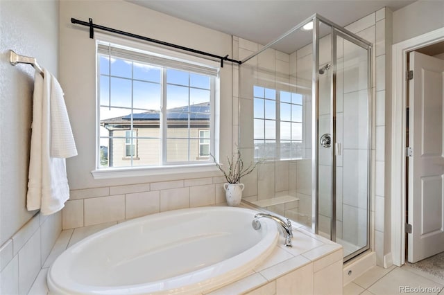 full bathroom featuring tile patterned flooring, a bath, and a shower stall