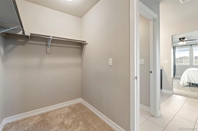 spacious closet with light carpet and a ceiling fan