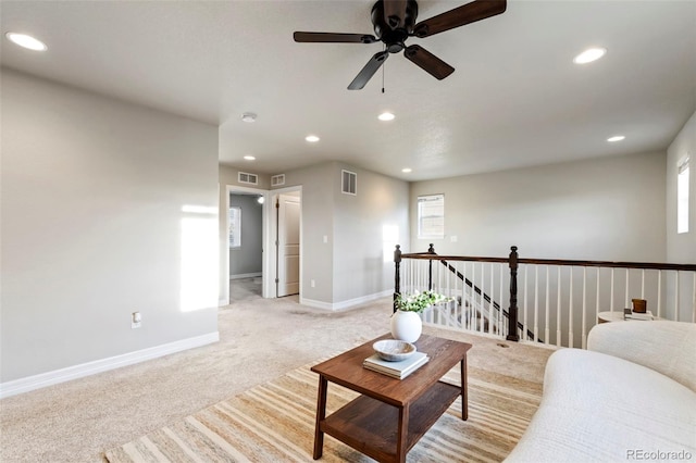 living area with recessed lighting, baseboards, visible vents, and light carpet