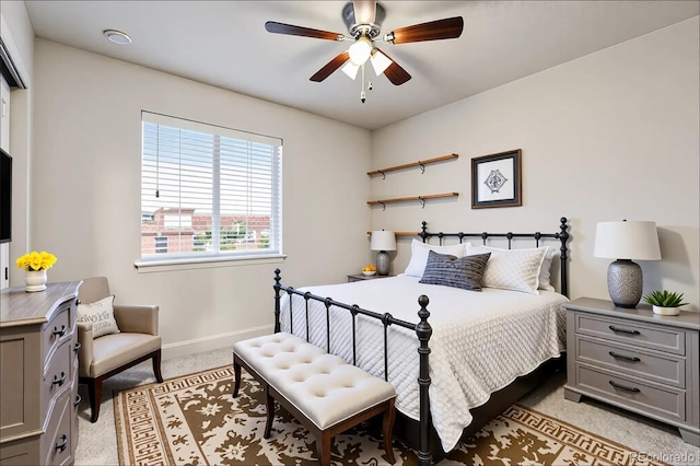 bedroom featuring light colored carpet, a ceiling fan, and baseboards