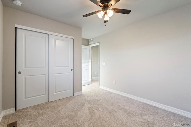 unfurnished bedroom with light colored carpet, baseboards, visible vents, and a closet