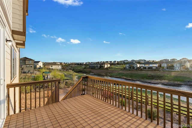 wooden deck with a residential view and a water view