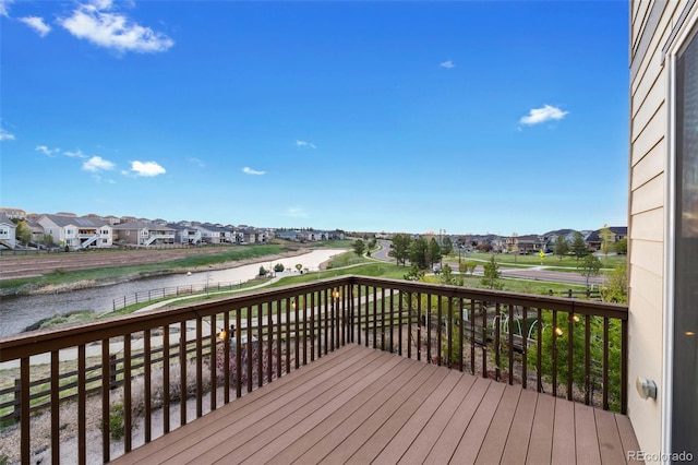 wooden deck featuring a water view and a residential view