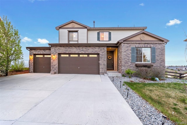 traditional home featuring fence, a garage, driveway, and brick siding