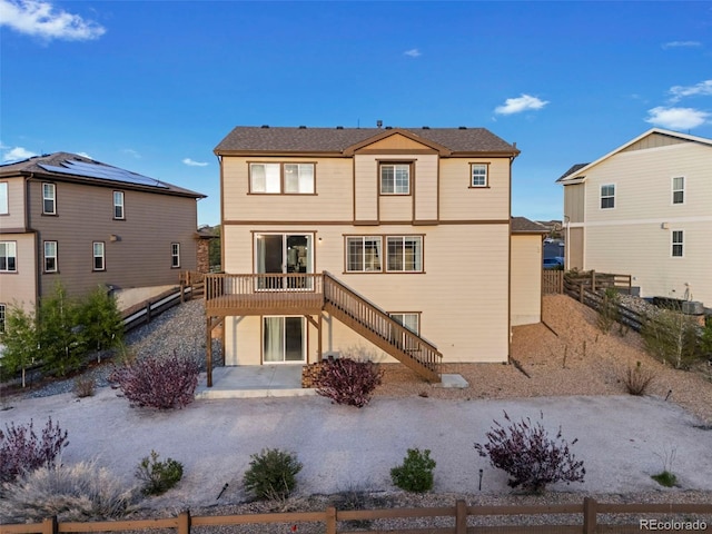 rear view of property featuring a wooden deck, a patio area, fence, and stairway