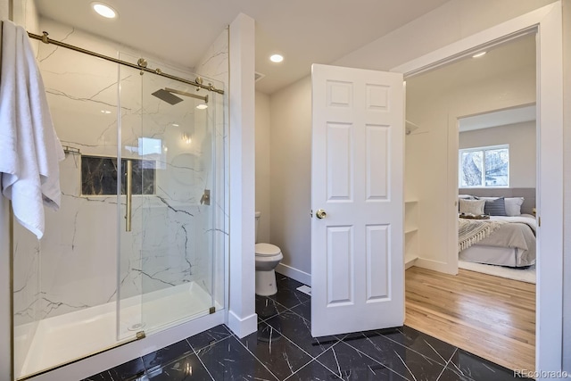 bathroom with hardwood / wood-style flooring, toilet, and a shower with shower door