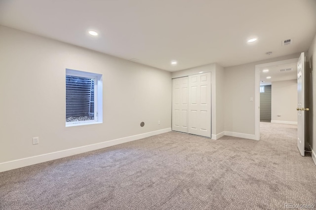 unfurnished bedroom with a closet and light colored carpet